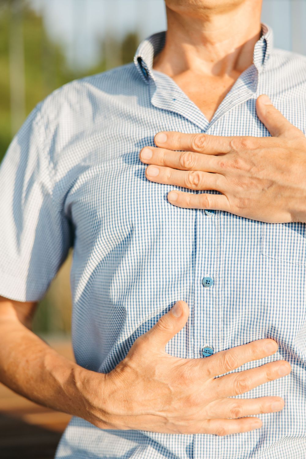 Man with his hands on his chest, illustrating COPD breathing symptoms